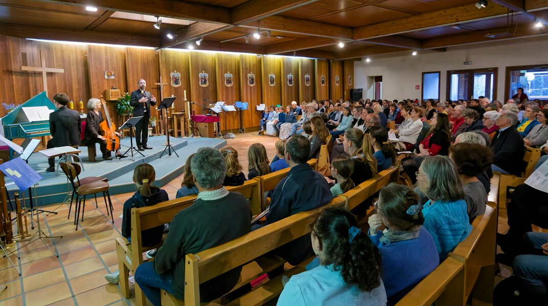 Speaker on stage presenting to an audience in an auditorium